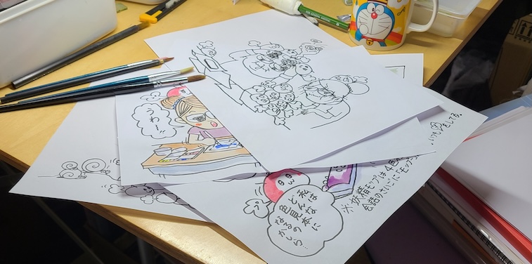 過去の作品と現在制作途中の作品が並ぶ机の上