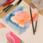 机の上に置かれた描きかけの水彩画と、そっと置かれた筆