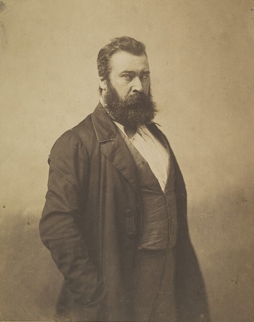 髭を蓄え、鋭くも慈しみ深い眼差しでこちらを見つめるジャン＝フランソワ・ミレーの肖像写真。