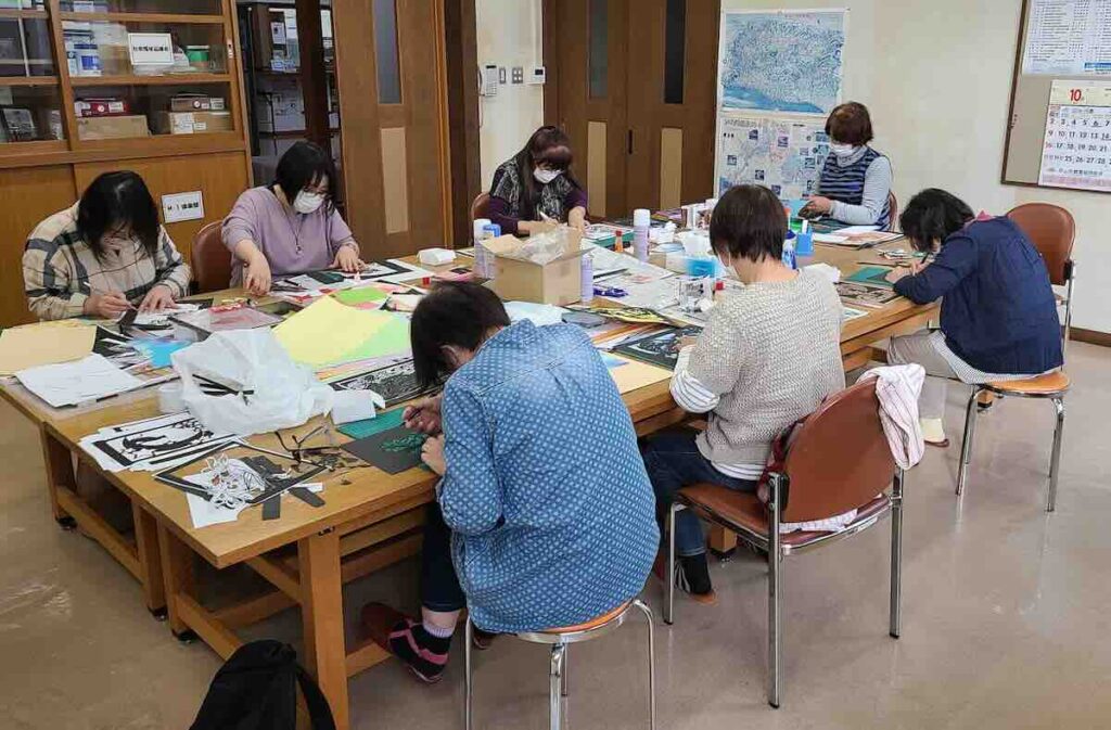 公民館で参加者が切り絵制作に集中している講座の様子
