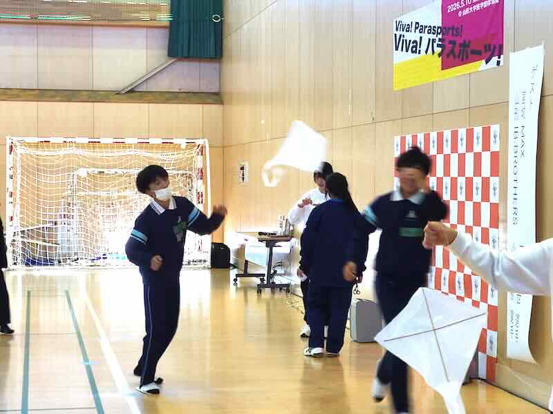 完成した凧を体育館で飛ばして楽しむ子どもたちの様子